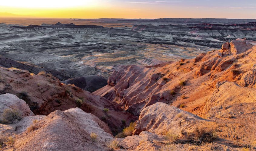 Sun shining over rocky red hills near our hotel in Winslow, AZ