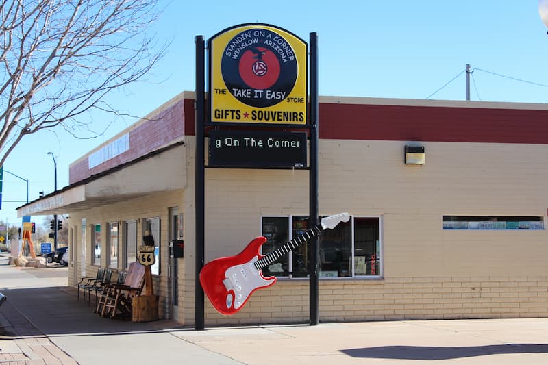 a red and white guitar hanging outside of a store