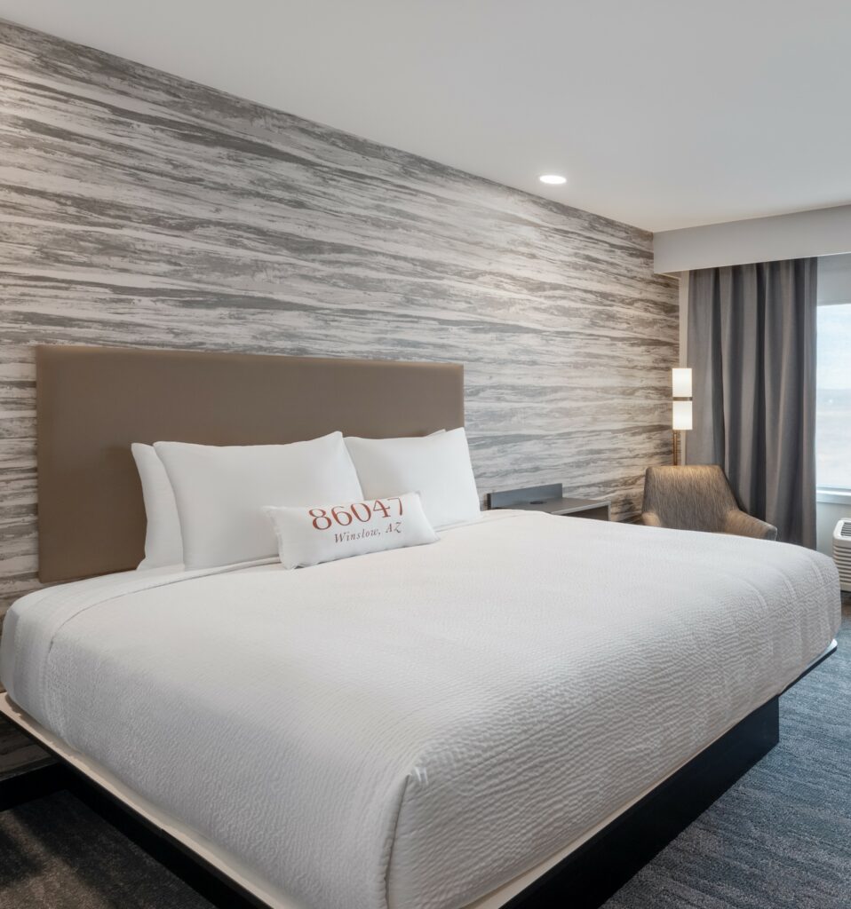 a hotel room with a large bed and a view of the ocean