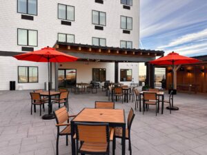 a patio with tables and chairs and red umbrellas