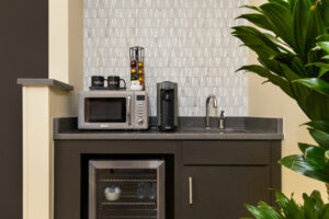 a microwave oven sitting on top of a counter next to a potted plant