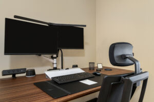 a desk with a computer monitor, keyboard and mouse