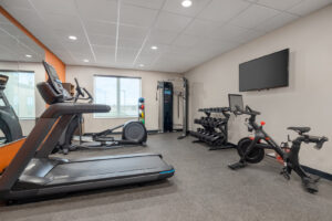 a gym with exercise equipment and a flat screen tv