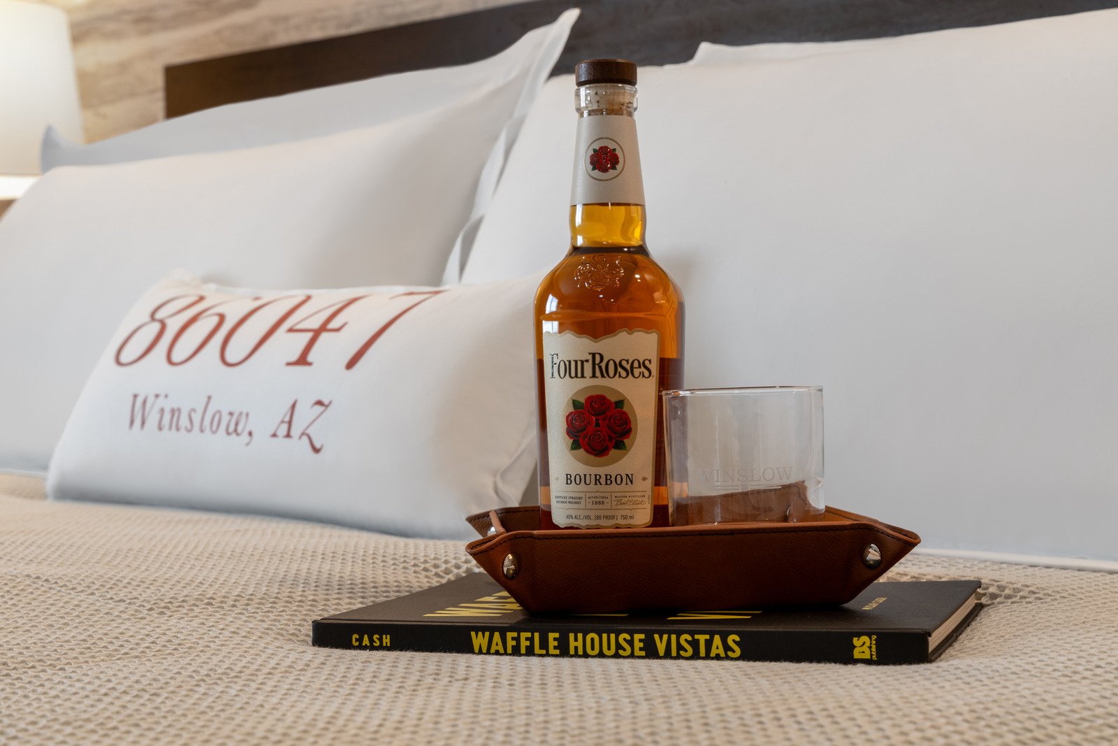 a bottle of wine sitting on top of a bed