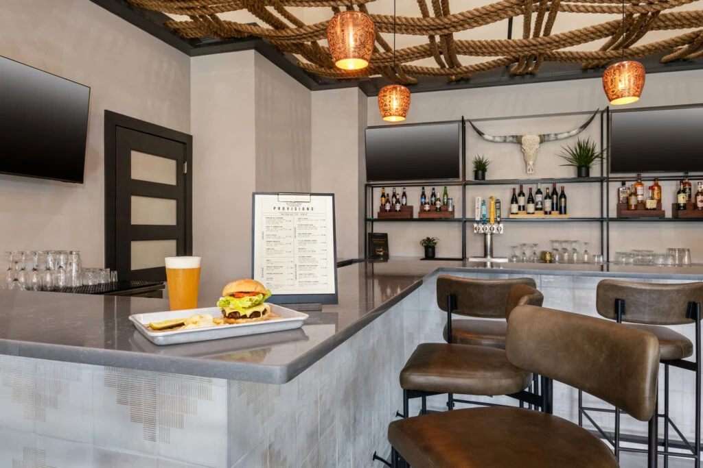 A burger and beer sit on a modern bar counter at one of the best Oklahoma City restaurants.